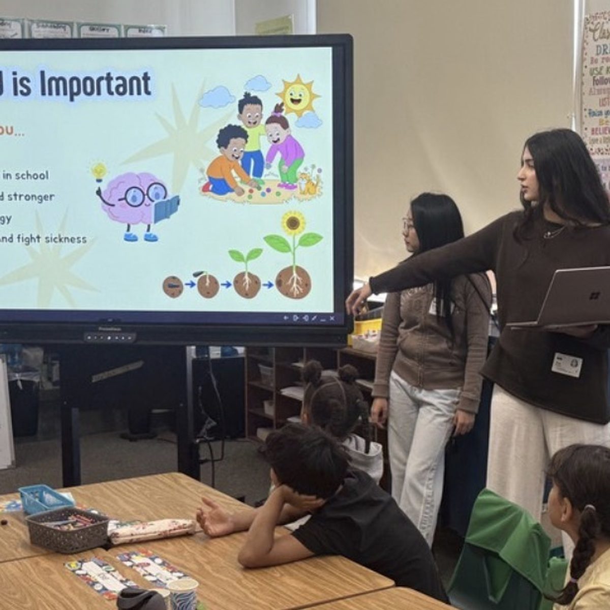 A student volunteer teaching a classroom lesson on nutrition