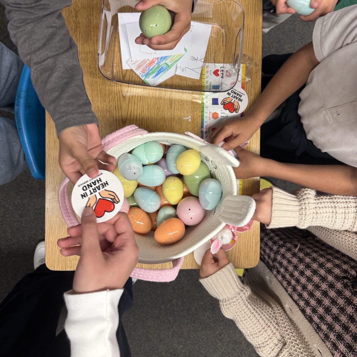 Children choosing eggs from a Heart in Hand basket